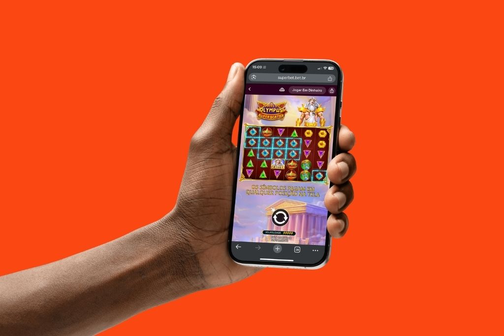 Uma mão segura um smartphone exibindo o jogo Gates of Olympus Super Scatter em uma tela vertical com fundo laranja vibrante. A interface mostra os símbolos coloridos sobre o cenário do Monte Olimpo com o personagem Zeus posicionado ao lado da grade de apostas.