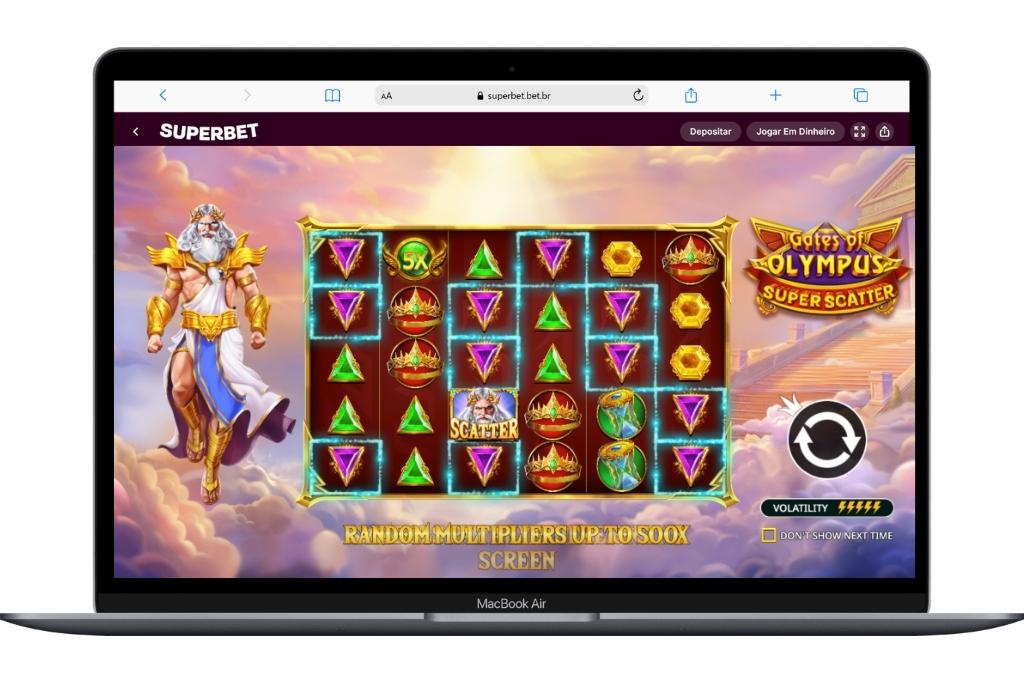 A tela de um MacBook Air apresenta a interface completa do jogo Gates of Olympus Super Scatter em modo paisagem, no site da Superbet. É possível ver detalhes do cenário mitológico, o logotipo oficial do game no canto direito e os cilindros preenchidos com joias e multiplicadores aleatórios.