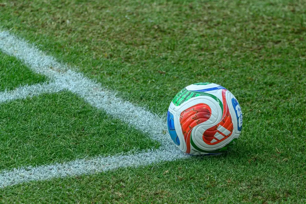 Bola oficial da Copa posicionada no canto do gramado próximo à linha lateral do campo, em imagem esportiva que simboliza estratégias para apostar nos favoritos da Copa do Mundo.