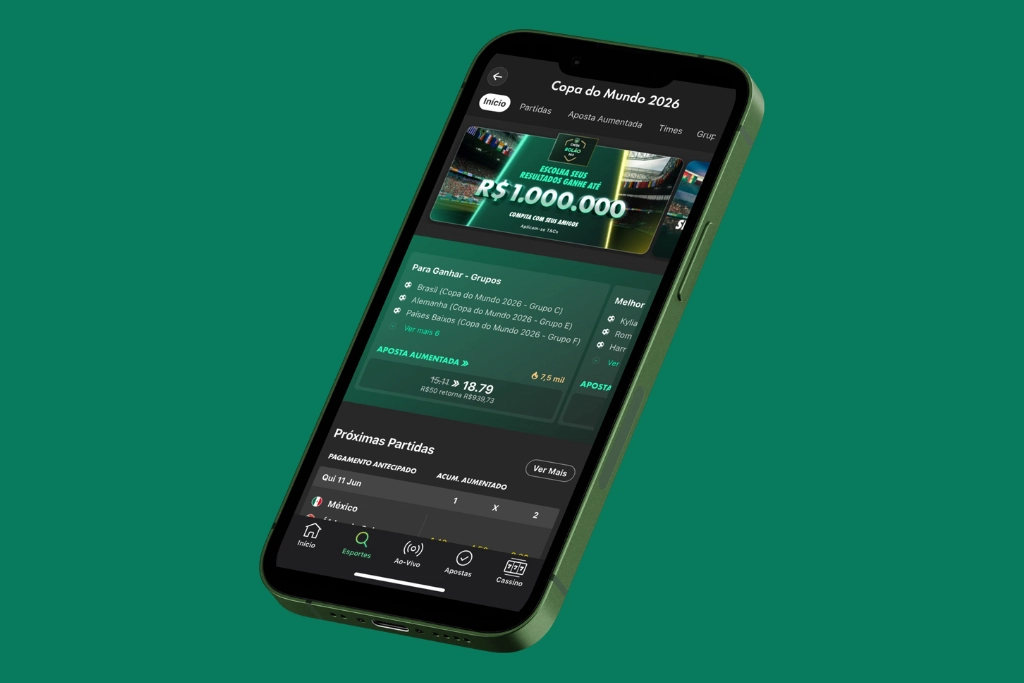 Smartphone posicionado diagonalmente mostrando a interface interna do bet365 app com uma promoção especial para a Copa do Mundo 2026, destacando um prêmio de R$ 1.000.000. Abaixo, são exibidas opções de apostas esportivas para grupos e próximas partidas em um layout escuro e verde.
